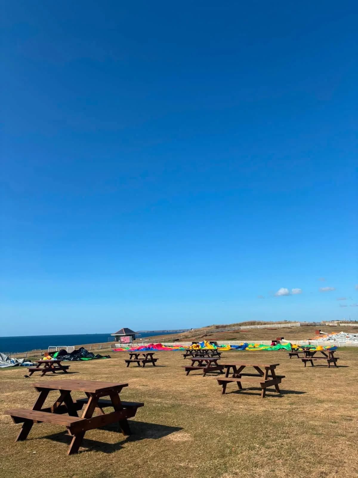 Several timber picnic tables in an outdoor recreation area