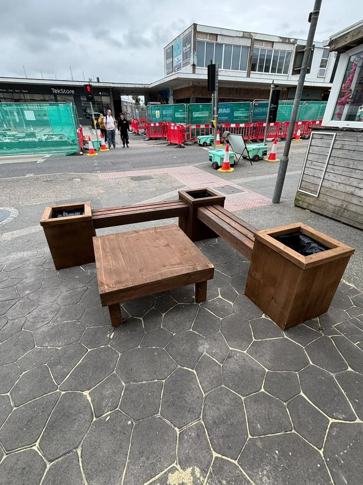 Stained timber planter bench and square planter boxes on paving